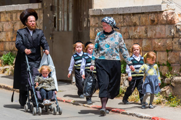 A traditional orthodox Judaic family with the child on the Mea Shearin street in Jerusalem, Israel. stock photo