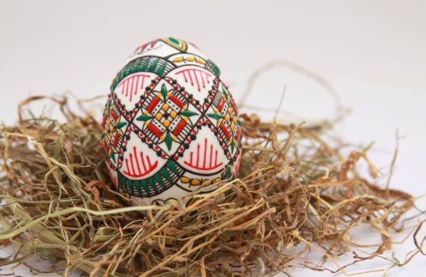 Traditional painted handmade Easter egg on hay stock photo