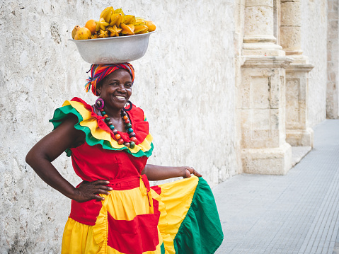 Traditional fresh fruit street vendor aka Palenquera in the Old Town of Cartagena in Cartagena de Indias, Caribbean Coast Region, Colombia.