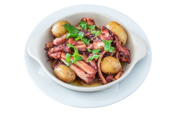 Traditional Portuguese dish of octopus and potatoes called polvo a lagareiro close-up on a white plate stock photo