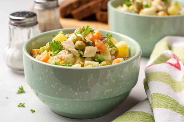 Traditional Russian salad Olivier in bowls on concrete background stock photo