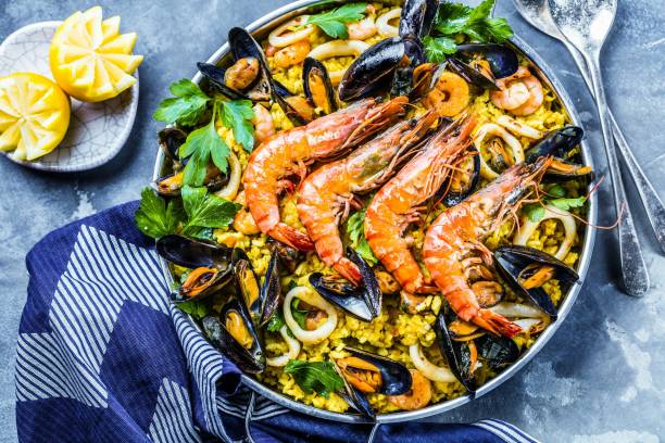 Traditional seafood paella in the pan on a wooden old table stock photo
