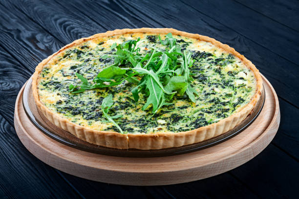 Traditional Spinach Quiche on dark wooden background. French cuisine. Restaurant, food menu, recipe, cafe concept. Free copy space for text. stock photo
