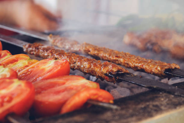 Traditional Turkish Adana Kebab or Kebap on the grill with skewers in the restaurant for dinner stock photo