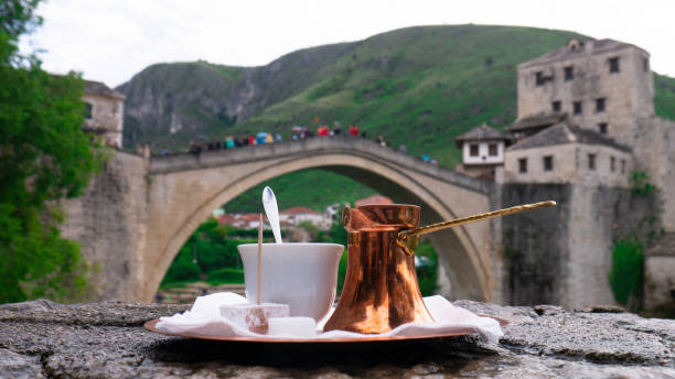 traditioneller türkischer kaffee und blick auf die altstadt von mostar und den fluss neretva. bosnischer kaffee in einem cezve mit türkischem genuss, mostar, bosnien und herzegowina. - kannestein stock-fotos und bilder