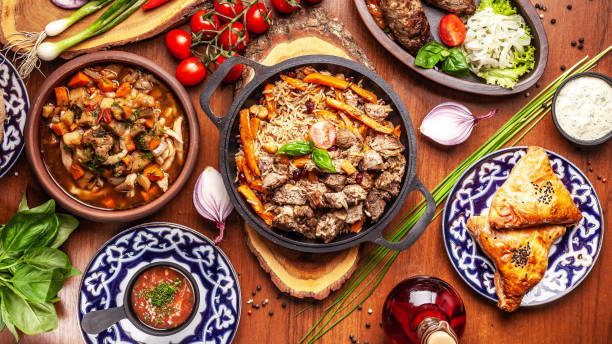 Traditional Uzbek oriental cuisine. Uzbek family table from different dishes for the New Year holiday. The background image is a top view. Traditional Uzbek oriental cuisine. Uzbek family table from different dishes for the New Year holiday. The background image is a top view. uzbekistan stock pictures, royalty-free photos & images