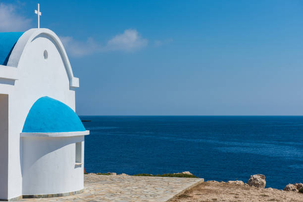 Traditional white chapel with a blue roof on the seaside. Agioi Anargyroi, Cyprus stock photo