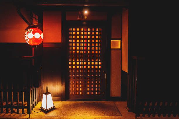 Traditional wooden door entrance with illuminated laterns in the old town Gion district in Kyoto, Japan stock photo