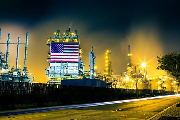 Traffic Streaks and Oil Refinery Headlights from cars streak across the frame in front of a large oil refinery complex in Los Angeles, CA oil refinery factory stock pictures, royalty-free photos & images