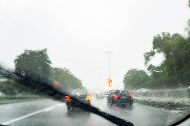 Traffic view of a rainy and gloomy day from inside of a car windshield stock photo