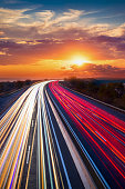 istock Trails  of cars lights on the asphalt car road. Sunset time with clouds and sun. Drive forward! Transport creative background. Long exposure, motion and blur."n 1352074036