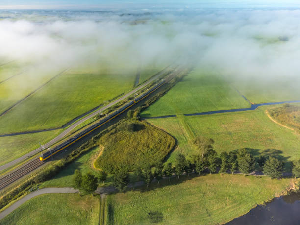 Train of the Dutch Railways NS driving through the countryside seen from above stock photo