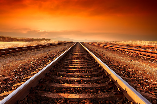 Train tracks goes to horizon in the majestic sunset.