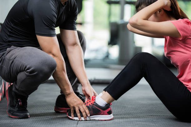 Trainer holding a woman in the leg exercise by Sid-ups. stock photo