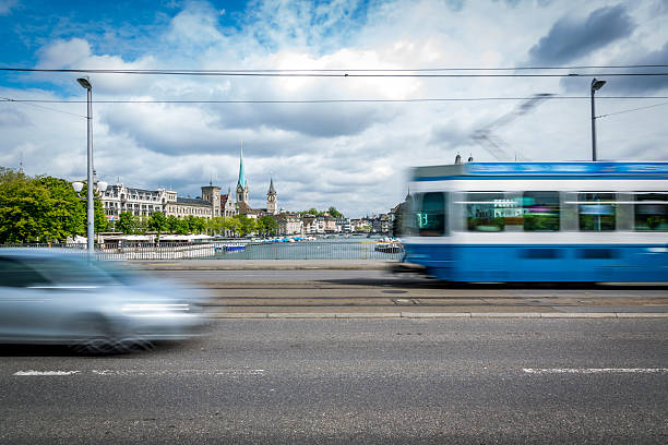 Tram and Car on a Bridge of Zurich, Switzerland A tram passing by the city center of Zurich in Switzerland. The tram is blurred due to motion and long exposure. zurich stock pictures, royalty-free photos & images