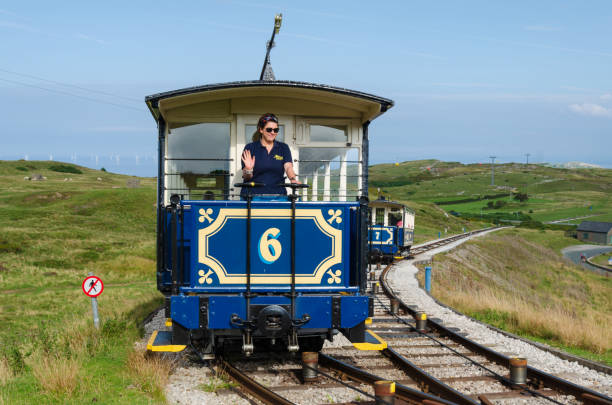 A tram driver gives a cheery wave on the Great Orme Tramway stock photo