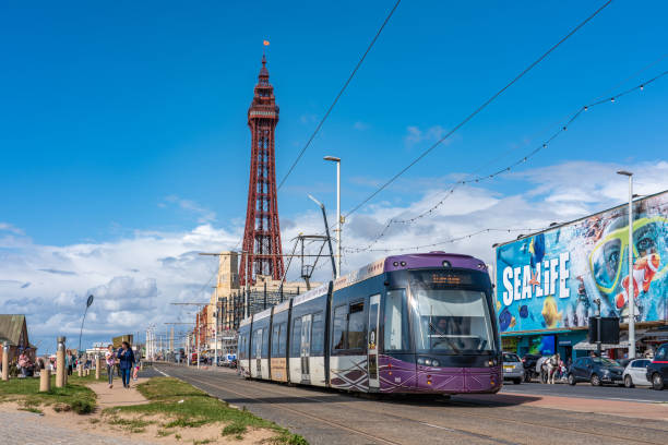 Tramway with the famous Blackpool tower This is a view of the tramway with a tram carriage and Blackpool Tower in the distance on August 12, 2019 in Blackpool blackpool tower stock pictures, royalty-free photos & images