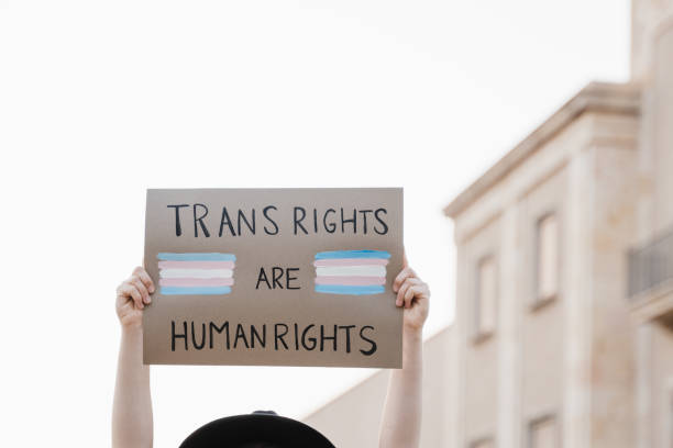 Trans woman at gay pride protest holding transgender flag banner - Lgbt celebration event concept stock photo