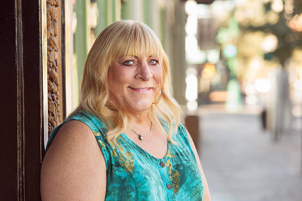Transgender blond lady smiling outside stock photo