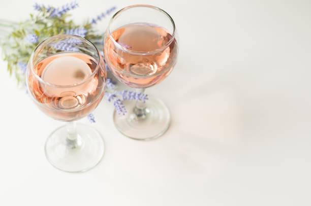 Transparent glass of wine. Pink wine Festive mood. Alcohol for a group of friends. Delicious drink. Light background.  Noble drink. Lavender and rose wine. Wine from lavender rose wine stock pictures, royalty-free photos & images