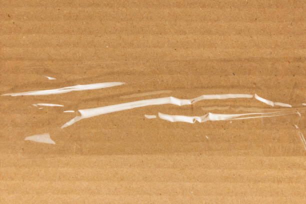 Transparent sticky tape on a cardboard surface stock photo