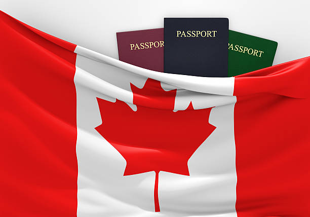 Travel and tourism in Canada, with assorted passports Canadian flag and three passports in different colors, representing travel to and from the country. 2015 stock pictures, royalty-free photos & images