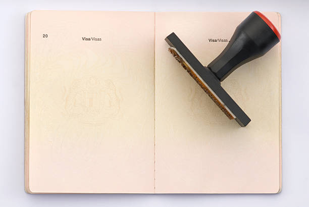 Travel Passport A empty pages of passport ready for stamping & Rubber stamp on top of the passport. Isolated on white with clipping path passport stamp stock pictures, royalty-free photos & images