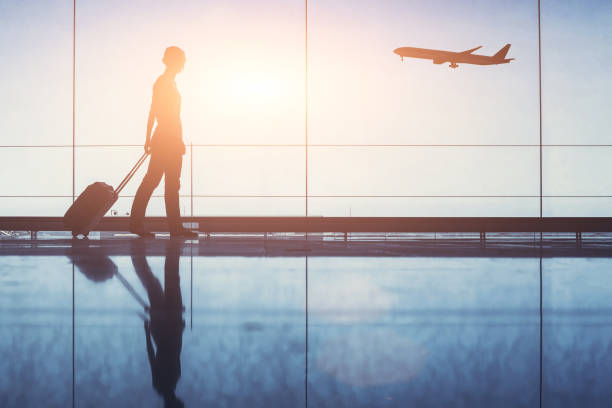 viaggio. silhouette di donna passeggera con bagaglio in aeroporto. - aeroporto foto e immagini stock