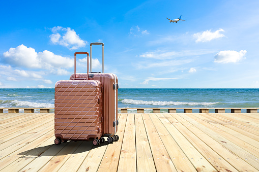 Travel suitcase on wood floor by the sea,travel concept.