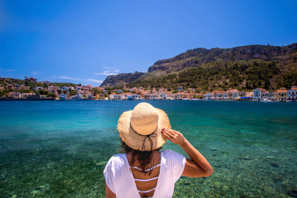 Travel to Greek Island Young woman at shore of Megisti (Kastellorizo) Island, Greece. mediterranean sea stock pictures, royalty-free photos & images