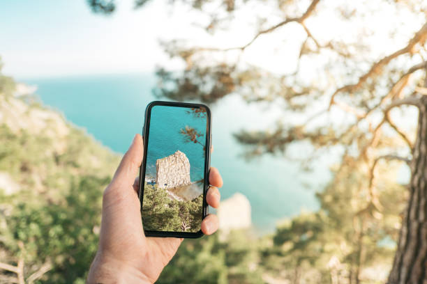 Traveler takes a photo on cell phone on nature. stock photo