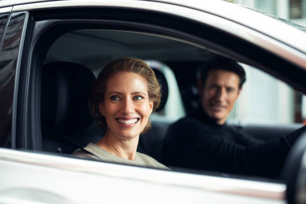 Traveling by a car Handsome adult couple is traveling by a car. They are looking at some point through the window and smiling. georgijevic frankfurt stock pictures, royalty-free photos & images