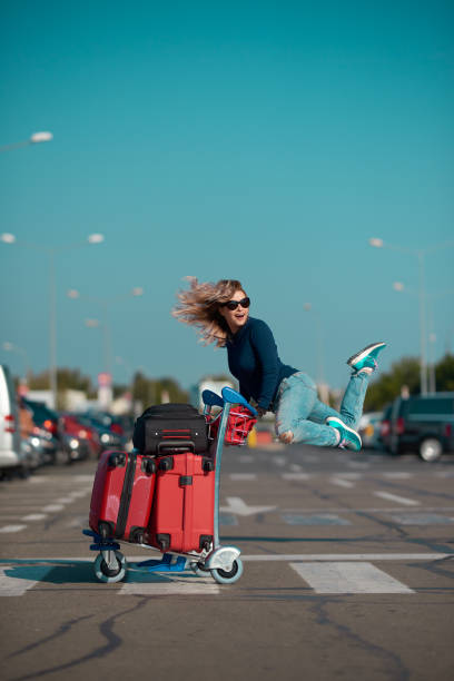 traveling is great laughing tourist woman with her suitcases jumping. enjoying her day, her vacation. luggage cart stock pictures, royalty-free photos & images