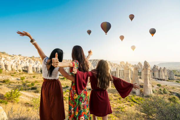 Traveling women looking at air balloons in sky in Cappadocia valley. Traveling women looking at air balloons in sky in Cappadocia valley. rock hoodoo stock pictures, royalty-free photos & images