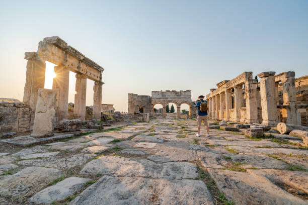 Traveller tourist is taking photo of Frontinus Gate in ancient ruins in Hierapolis , Pamukkale UNESCO, Photographer, Camera, Travertine pools, Greek architecture ancient agora stock pictures, royalty-free photos & images