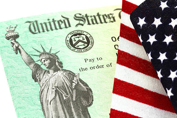 USA Treasury IRS refund check on American flag stock photo