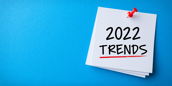 Trends 2022 Word in Yellow Sticky Note on Blue Background