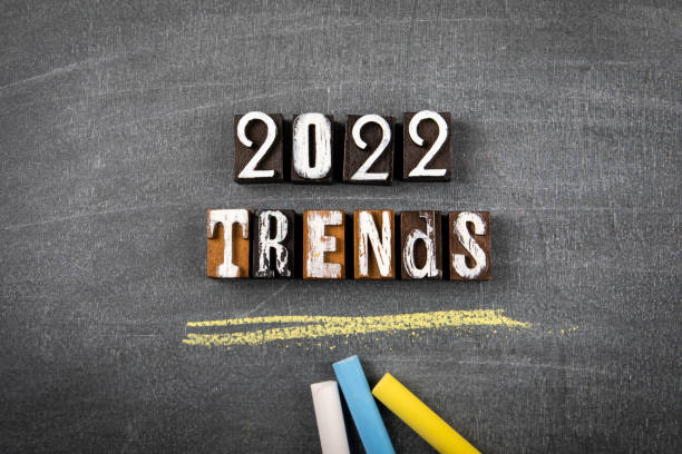 2022 Trends. Text from wooden letters and colored pieces of chalk on a chalk board stock photo