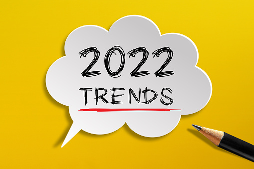2022 Trends written on speech bubble with pencil on yellow background