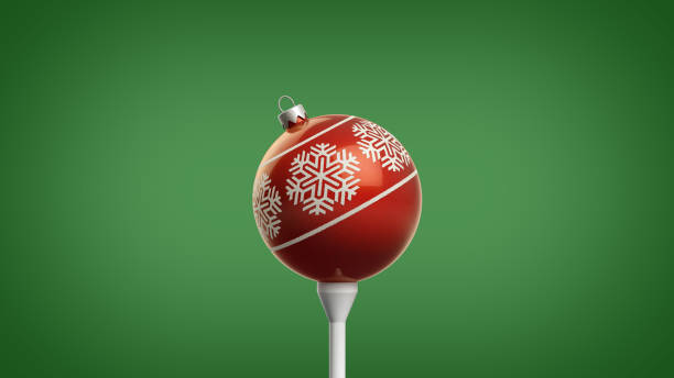 Trendy Retro 3D Illustration of Shiny Red Christmas Ornament with a Snowflake Design on a Golf Tee Isolated on a Fresh Green Background with Clipping Path stock photo
