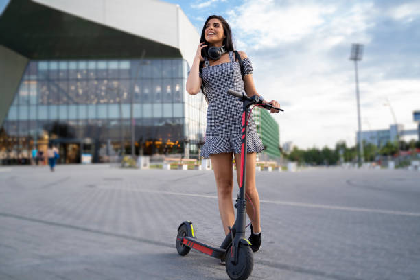 trendy jonge vrouw in de stad met haar e scooter - elektrische step stockfoto's en -beelden