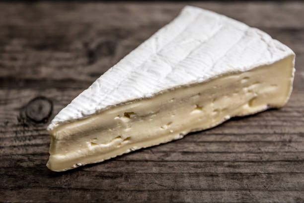 triangle of fresh brie cheese stock photo
