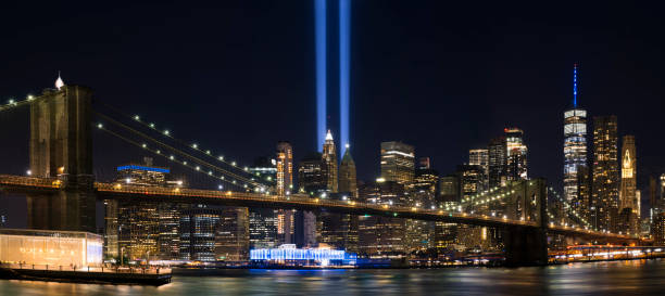 9/11 Tribute in Light 9/11 Tribute in Light. Brooklyn Bridge and Lower Manhattan illuminated at night. View from Main Street Park. 911 memorial stock pictures, royalty-free photos & images