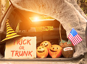 istock Trick or trunk. Concept celebrating Halloween in trunk of car. New trend celebrating traditional October holiday outdoor. Social distance and safe alternative celebration during coronavirus covid-19 1278898108