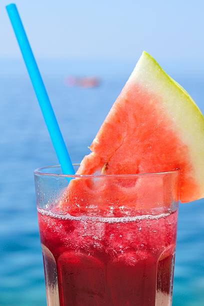Fresh tropical fruit cocktail with water melon slice on a beach....