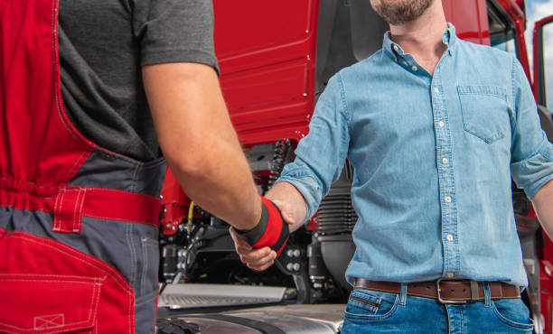 Truck Driver and His Mechanic Hand Shaking stock photo