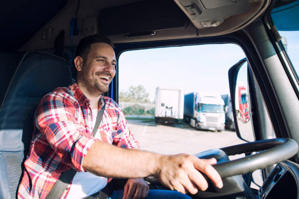 Truck driver job. Middle aged trucker driving truck. Professional middle aged truck driver in casual clothes driving truck vehicle going for a long transportation route. truck driver stock pictures, royalty-free photos & images