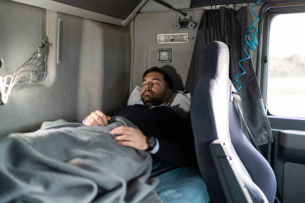 Truck driver sleeping in cabin bed on truck stop stock photo