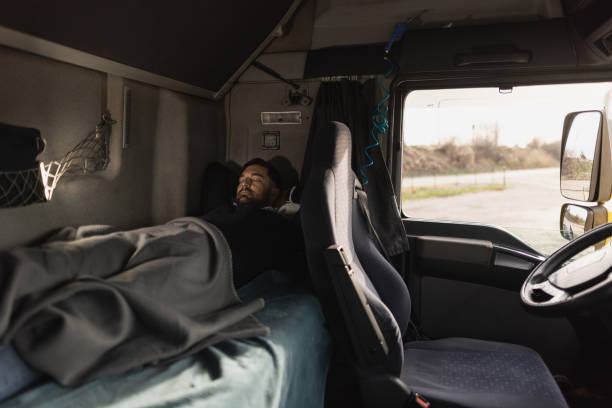 Truck driver sleeping in cabin bed on truck stop stock photo
