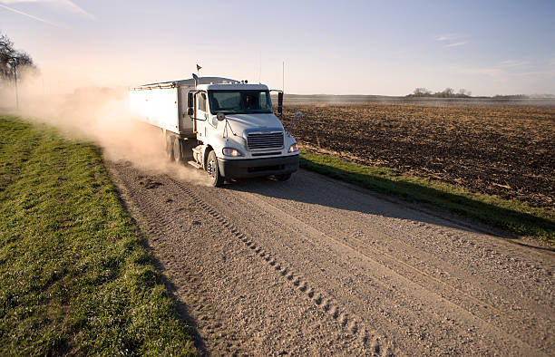 Truck hauling grain on a dusty rural midwest road. stock photo